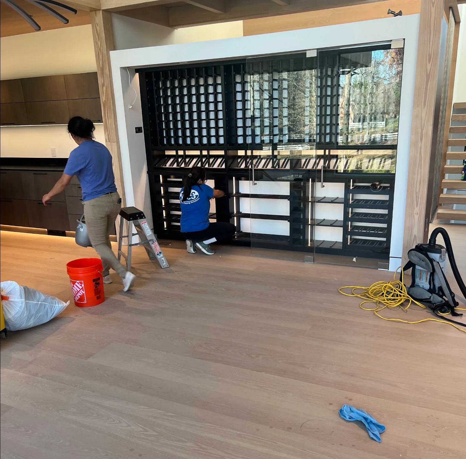 Crew cleaning a new-construction home's glass wine cellar