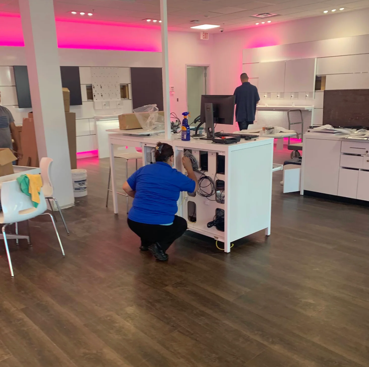 Crew cleaning desks and fixtures in a retail space after construction